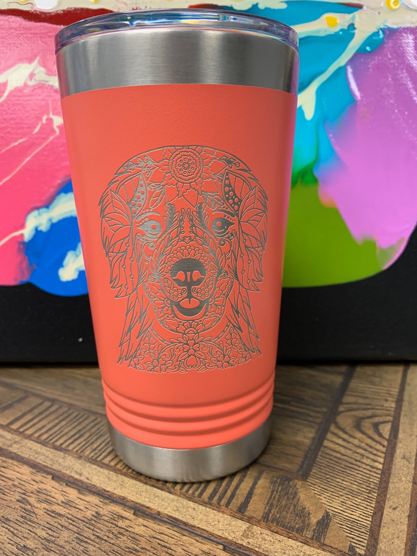 Image of an insulated tumbler in Coral with metal rim, clear plastic lid, and a beautiful mandala-styled Retriever laser etched in the side of the cup.